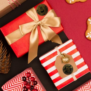 Christmas gift wrapping set with red patterned paper, gold ribbon and black stickers