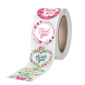 Roll of floral Thank You stickers with elegant rose designs and gold script lettering