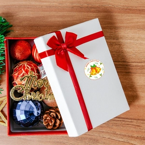 Close-up of a Merry Christmas sticker seal on a gift box with festive ornaments