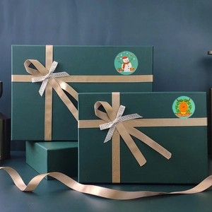 Close-up of green Christmas gift boxes with champagne silk ribbons and festive stickers