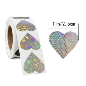 Macro detail of 1-inch heart-shaped silver holographic laser sealing stickers on a roll