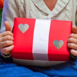 Heart-shaped holographic laser stickers applied on a red gift box for decoration