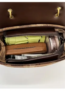 Close-up of retro brown handbag interior with spacious storage and striped lining