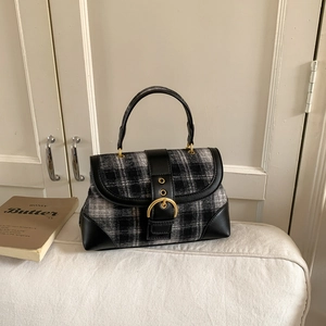 Detailed view of British style plaid handbag with leather straps and golden metal buckle