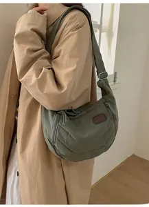 Detail of army green nylon messenger bag with adjustable strap and side pocket