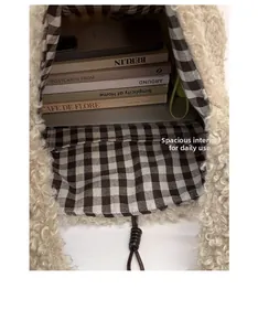 Spacious interior of plush tote bag with plaid lining and drawstring closure detail