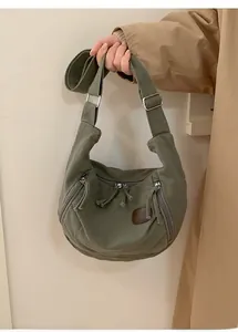 Detail of army green nylon crescent bag with adjustable wide strap and leather patch