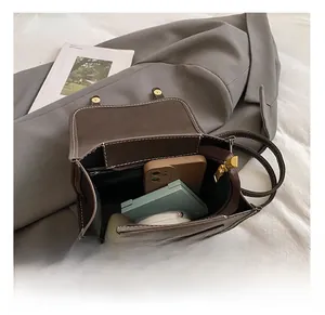 Internal view of brown leather backpack showing capacity for phone and cosmetics