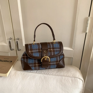 Detail of vintage plaid underarm bag with brown leather trim and metallic buckle