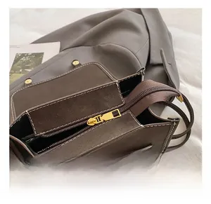 Detail shot of vintage dark brown leather bag with gold zipper and white stitching accents