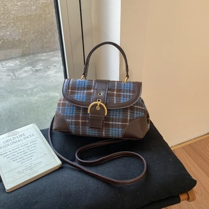 Close-up of vintage plaid fabric and leather拼接 detail on a retro shoulder bag