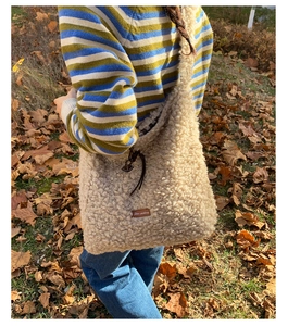 Detail of soft beige faux fur tote bag showing the plush texture and leather star label