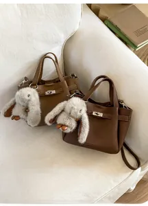 Détails du sac seau en cuir grainé avec fermoir métallique et breloque lapin en peluche
