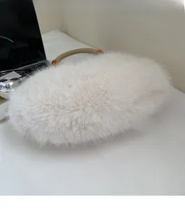 Detail of white plush moon bag featuring faux fur texture and circular top handles