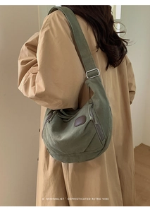 Detail of olive green canvas crossbody bag with leather patch and adjustable strap