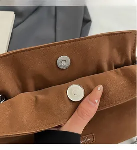 Close-up of magnetic snap closure on a vintage brown matte leather bucket bag
