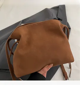 Detail showing soft pleated caramel leather texture and craftsmanship of the cloud crossbody bag