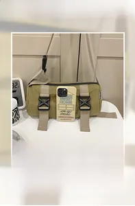 Detailansicht einer gelb-grünen Karo-Zylindertasche zeigt Kapazität mit Smartphone