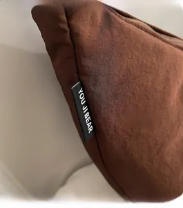 Detail of dark brown nylon crossbody bag featuring the YOU JI BEAR brand woven label