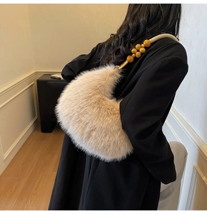 Détail du sac en fausse fourrure avec bandoulière en perles jaunes et forme croissant