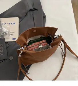 Interior view of brown matte bucket bag showing spacious storage with herringbone lining