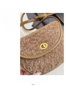 Detailansicht der braunen Lammfell-Satteltasche mit goldenem Metalldrehverschluss