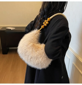 Détail du sac demi-lune en peluche beige avec anse en corde et perles de bois déco