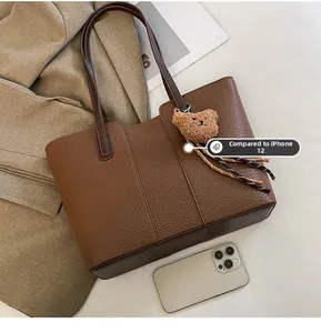 Brown lychee leather tote bag shown with iPhone 12 for scale and size comparison
