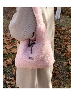 Close-up of pink fuzzy tote bag with drawstring detail and Star-picking leather label