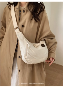 Détail du sac croissant en toile crème avec texture plissée et bandoulière réglable