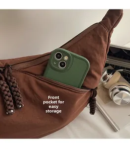 Detail showing a dark brown crescent bag with a zipper pocket for storing a smartphone