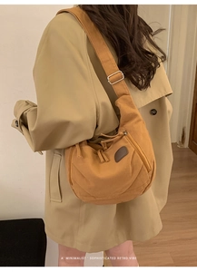 Détail de la bandoulière réglable et boucle en métal argenté sur sac en toile