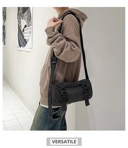 Detailansicht einer schwarzen karierten Zylindertasche mit verstellbaren Gurten am Modell