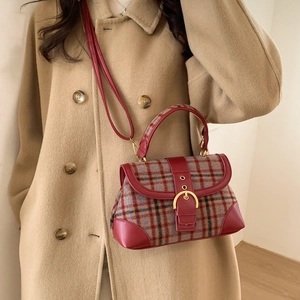 Detail of plaid texture and gold buckle on a retro shoulder bag with leather trim