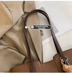 Detail showing comfortable smooth handles of the dark brown pebbled leather tote bag