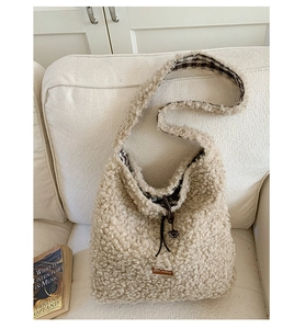 Detail of plush tote bag showing cream faux fur texture and brown drawstring closure