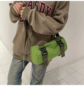 Detail einer grünen Zylindertasche aus Nylon mit strukturierter Oberfläche und Trageriemen