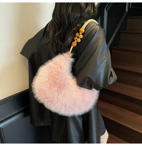 Détail du sac demi-lune en fausse fourrure rose avec bandoulière en perles de bois