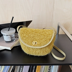 Dettaglio della borsa a sella in peluche giallo con chiusura a scatto dorata