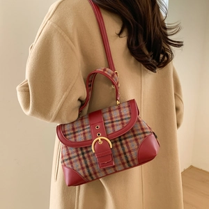 Detailed lifestyle shot of a retro plaid handbag with gold horseshoe buckle and leather trim