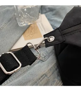 Détails des crochets en métal argenté brillant et de l'anneau D sur le sac en toile noir