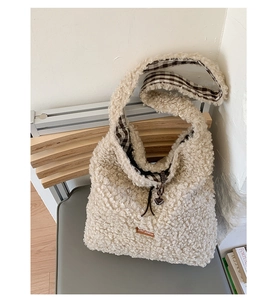 Close-up of fuzzy beige tote bag showing plush texture and brown plaid lining details