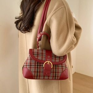Detail of vintage plaid handbag with burgundy leather trim and golden horseshoe clasp