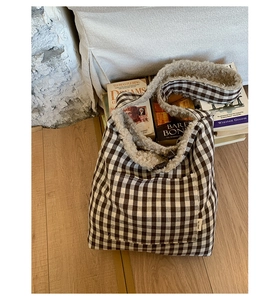 Detail of checkered tote bag featuring a horn button closure and faux shearling trim