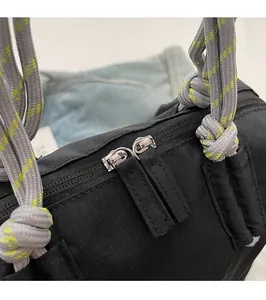 Détail de la double fermeture éclair métallique sur un sac en toile noire à cordes