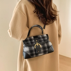 Detail of vintage plaid handbag featuring leather patchwork and large gold buckle