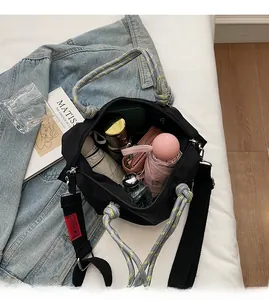 Détail de l'intérieur d'un grand sac fourre-tout en nylon noir avec anse en corde