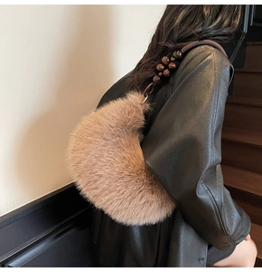 Détail du sac demi-lune en peluche marron avec bandoulière décorative en perles de bois