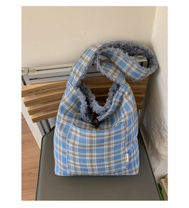 Detailed view of blue plaid tote bag featuring soft blue fleece lining and front pocket