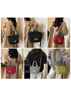 Détail montrant les sacs cabas en nylon en plusieurs couleurs avec des poignées tissées